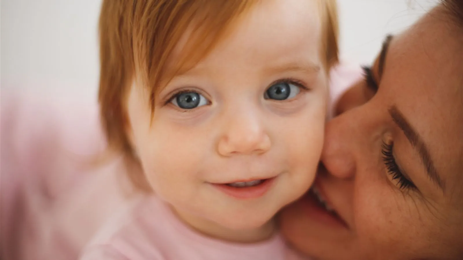 Mother smiling and holding her baby close to her face