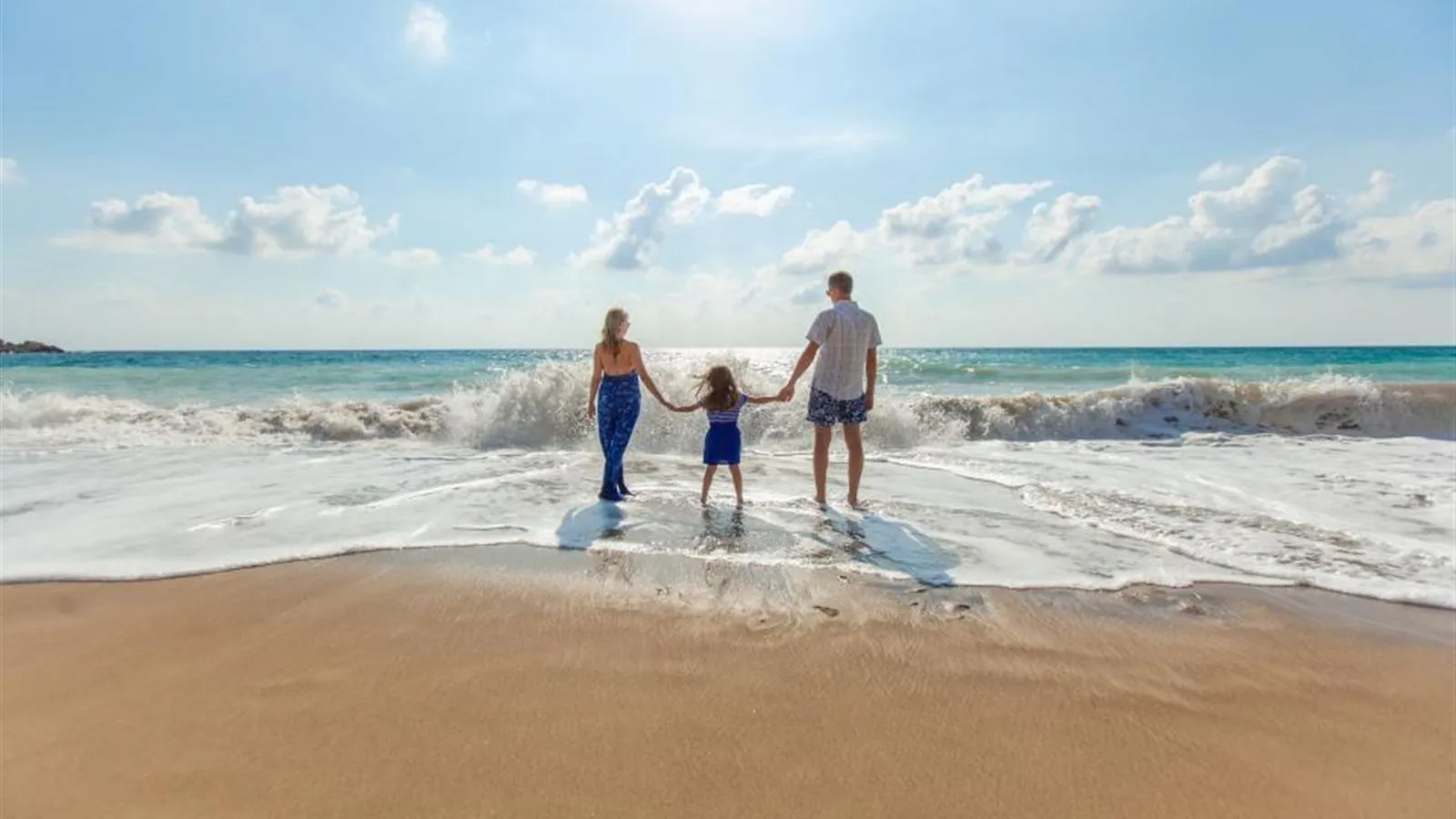 Family walking together along a sunny beach